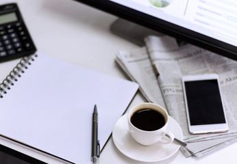 cup of coffee with Newspaper,computer and smartphone on white table.