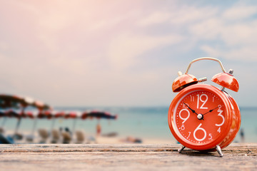 alarm clock on table and sea background, concept time to travel