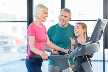 Fototapeta premium old sport couple and girl training on treadmill in fitness class