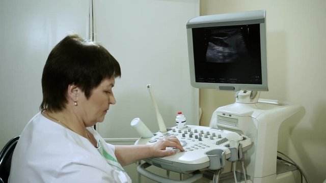 Female doctor examining the woman's thyroid gland using an ultrasound scanner. HD