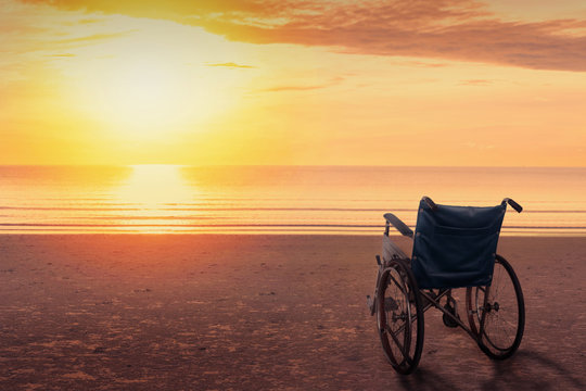 Wheelchairs parked on the beach at sunset time, in a lonely atmosphere.