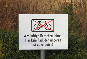 Hinweisschild für Radfahrer an einem abschüssigen Weg