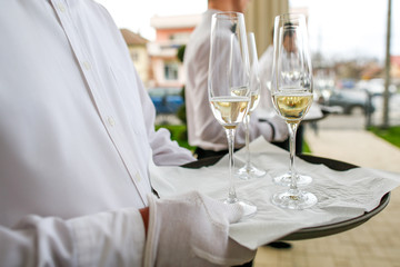 Waiter serving glasses of champagne at wedding reception