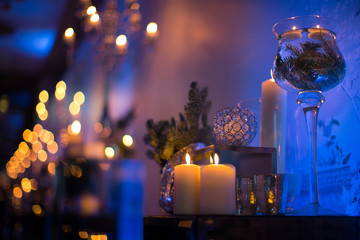 Indoors wedding decoration in the evening with candles and fir branches