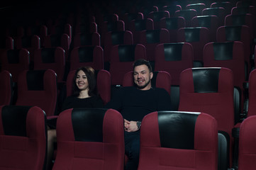 Happy romantic couple watching movie in theater