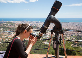 Portrait of woman tourist looking in telescope