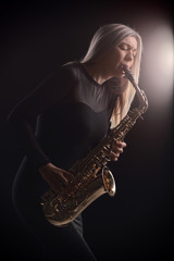 Naklejka premium Female jazz musician playing a saxophone during a concert