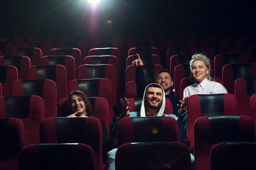 Fototapeta na wymiar Happy smiling friends watching film in theater