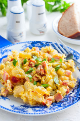 Potatoes with ham, eggs, marinated cucumbers on a plate, selective focus