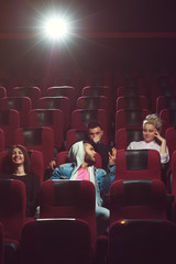 Young friends watching movie in cinema theater