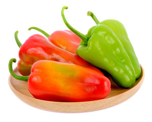 Sweet pepper in wooden dish isolated on white background