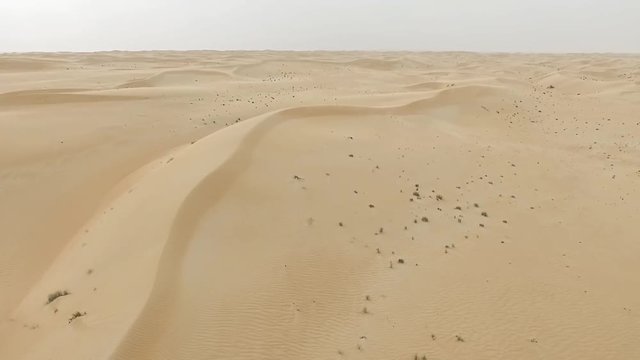 Flying over Arabian desert HD video. Flight aerial top view of dry sandy dune hill and barchan sand terrain nature landscape background