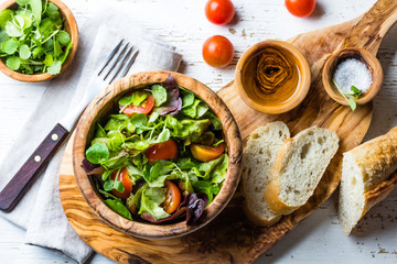 Vegetarian lettuce tomatoes salad in olive wooden bowl