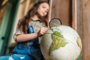 little girl with magnifying glass and globe. education kids concept