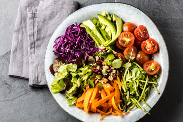 Bowl with vegetables and nuts. Vegan Buddha bowl on slate background