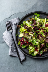 Healthy lettuce watercress salad with pomegranate. Top view