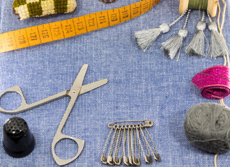 Beautifully laid out accessories for needlework on a jeans background