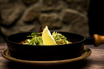 seafood saute served in a small skillet with a slice of lemon