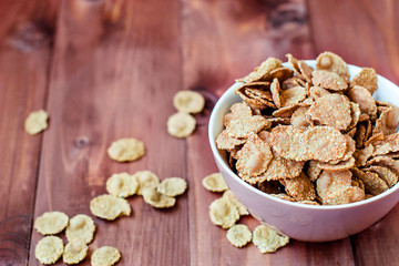 Flakes on a wooden table. Cereal flakes in a rustic style. Flakes for breakfast.