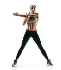 Strong girl with perfect body performs fitness exercises on white background. Strength and motivation