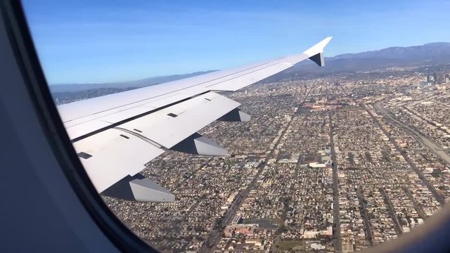 Fl&uuml;gel mit Landeklappen eines Flugzeuges bei Landung in Los Angeles am International Flughafen LAX in Zeitraffer