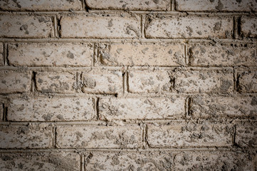Grunge background. Close-up part of old gray brick wall, stained of cement.