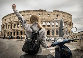 Woman tourist near the Coliseum in Rome under sunlight and blue