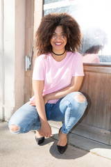 cheerful black mixed woman in street fashion