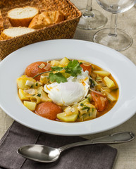 Potato soup with tomato and a poached egg.