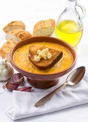 A bowl of traditional garlic soup topped with fried bread.