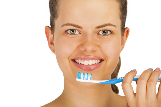 Young woman brushing teeth over white backgrund.