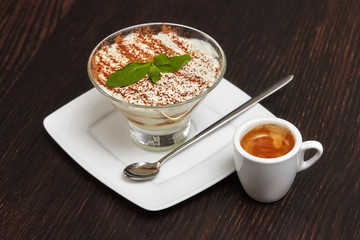 Tiramisu creme cake dessert in glass with mint leaves