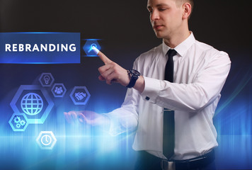Business, Technology, Internet and network concept. Young businessman working on a virtual screen of the future and sees the inscription: Rebranding