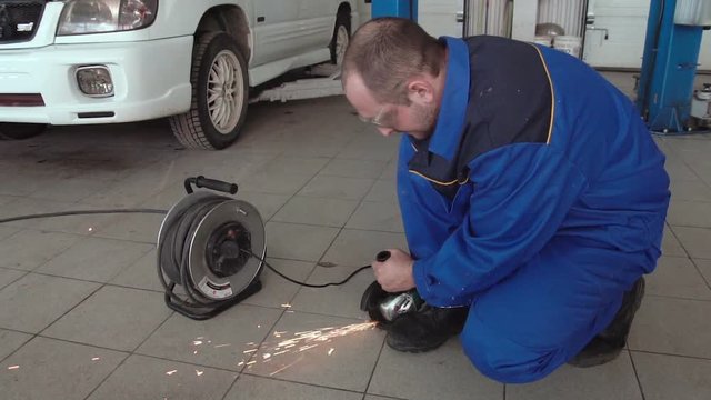 car mechanic work with circular saw cutting metal with sparks in super slow motion 120 fps