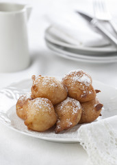 Sweet homemade beignets covered with powdered sugar.