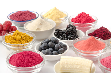 Verschiedene Fruchtpulver und Früchte