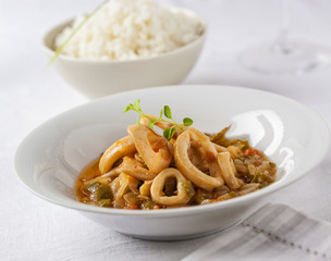 Squid rings cooked in a tasty sauce served with rice.