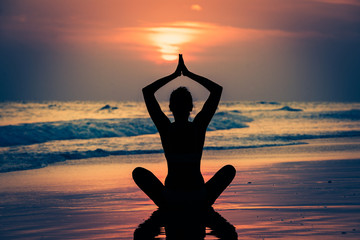 Kobieta ćwicząca jogę przy zachodzie słońca - obrazy, fototapety, plakaty
