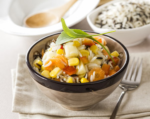 Delicious fresh rice salad with corn, tomato, melon and carrot.