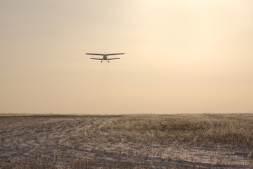 Fototapeta na wymiar Airplane flying at sunset.