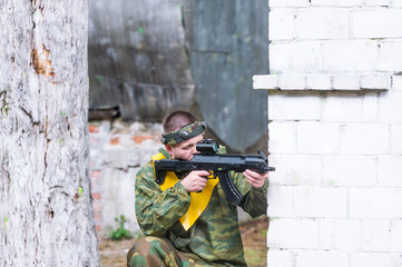 Fototapeta premium Man playing paintball in overalls with a gun