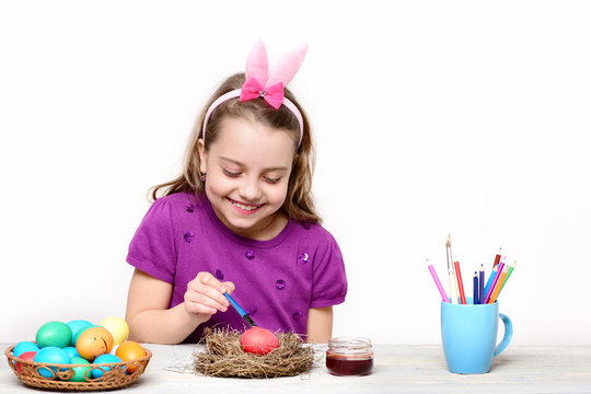 small happy baby girl with easter eggs isolated on white