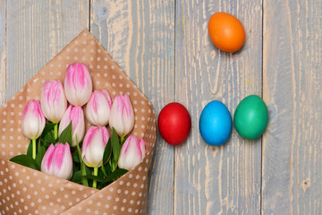 Obraz na płótnie Canvas colorful easter eggs in nest, pink beautiful tulips, mothers day