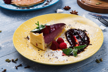 Restaurant dessert. Berry cheesecake on blue wood