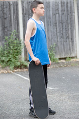 Teenage boy outside with a skateboard