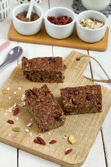 Energy bars with oat, Goji berries, sesame, chocolate and honey. White background, white pottery.
