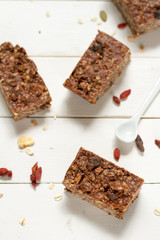 Energy bars with oat, Goji berries, sesame, chocolate and honey. White background, white pottery.