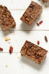 Energy bars with oat, Goji berries, sesame, chocolate and honey. White background, white pottery.