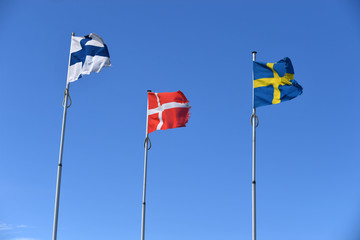 die fahnen aus Schweden, Norden und Dänemark wehen im wind vor blauem Himmel