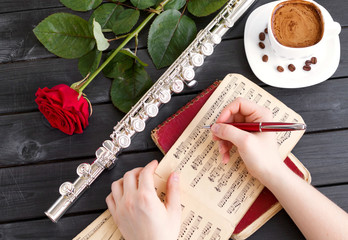 Musical background, poster - flute, rose, coffee, notes, symphony orchestra. Musical still life.